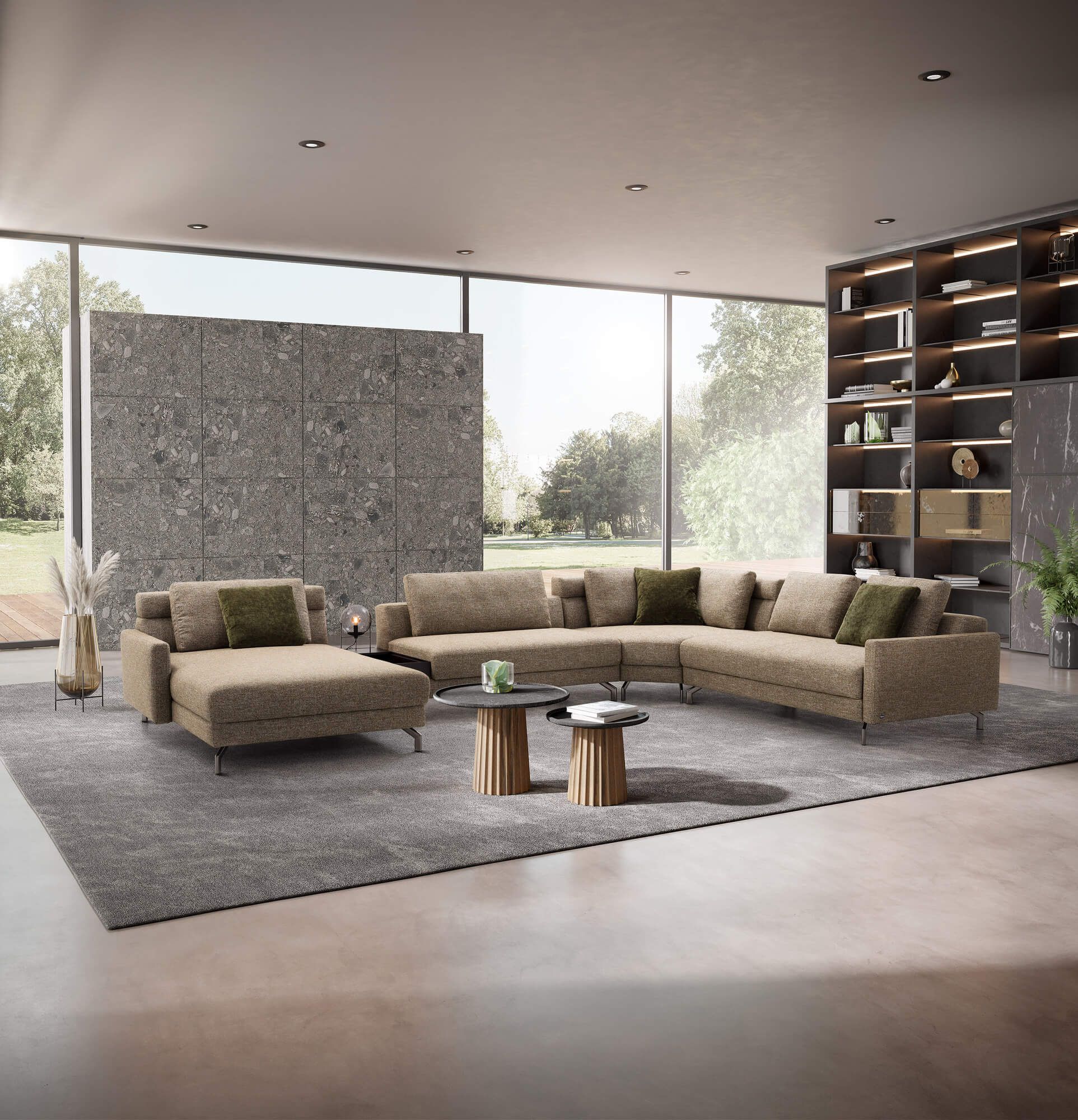 Helles Wohnzimmer mit großer Eckcouch, Couchtischen und Regalen am Fenster