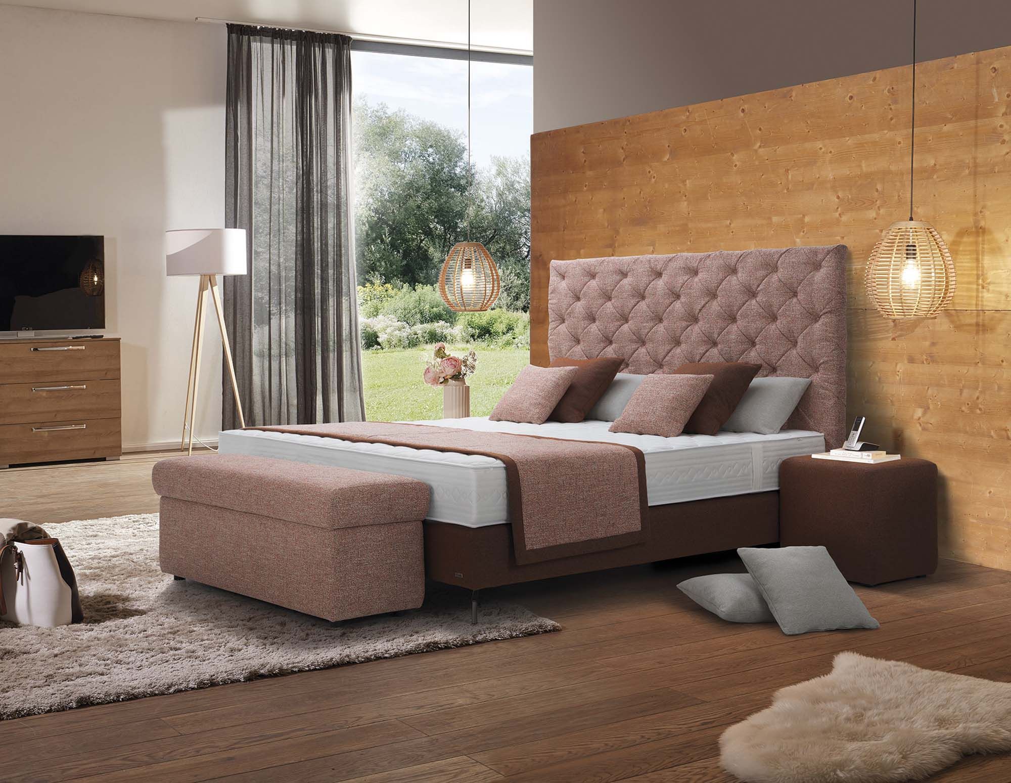 elegantes Schlafzimmer mit gepolstertem Boxspringbett, Holzwand und stimmungsvoller Beleuchtung